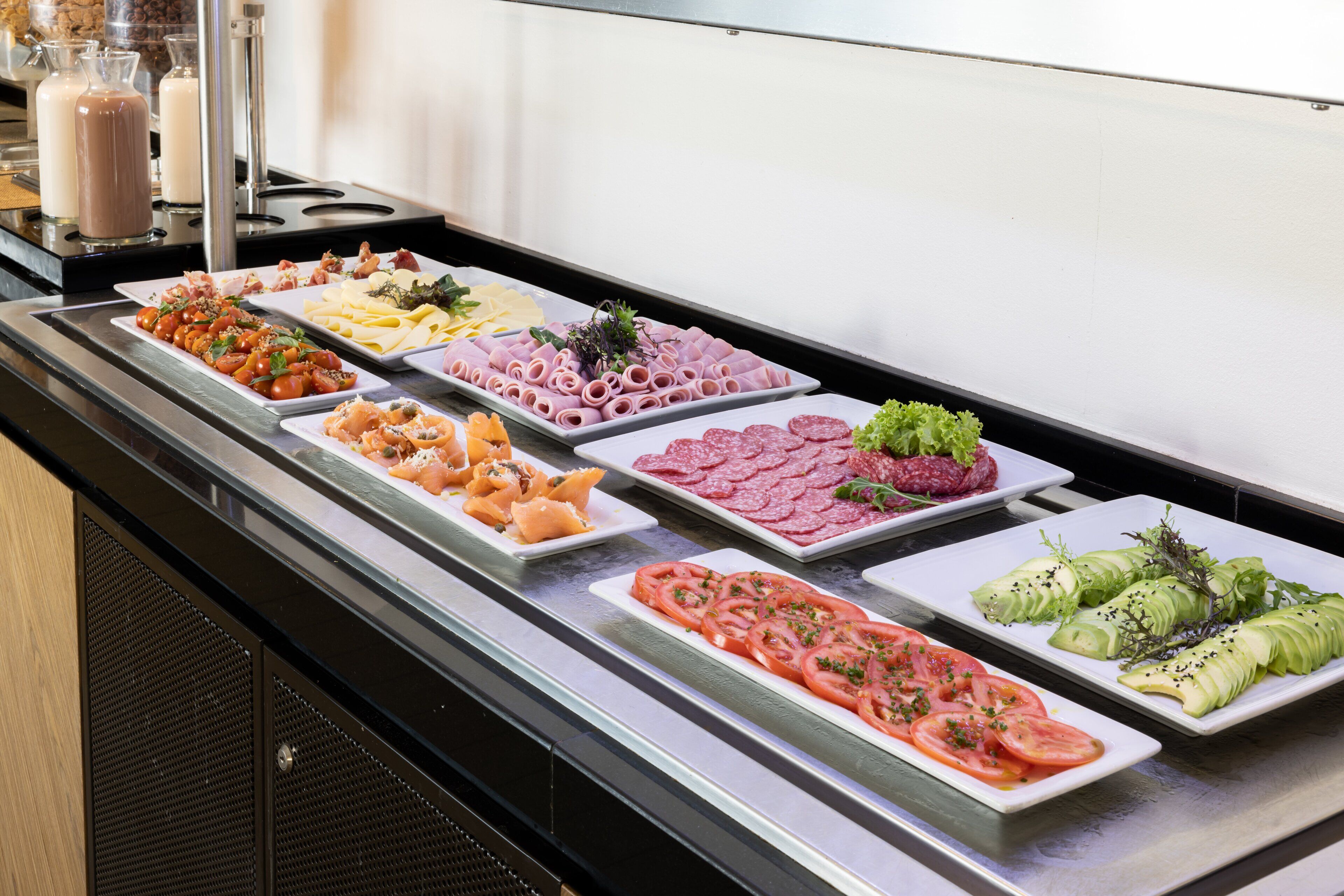 A buffet with various food items including meats, cheeses, and vegetables.