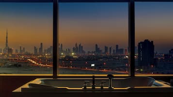 A cityscape view from a window with a bathtub in the foreground.