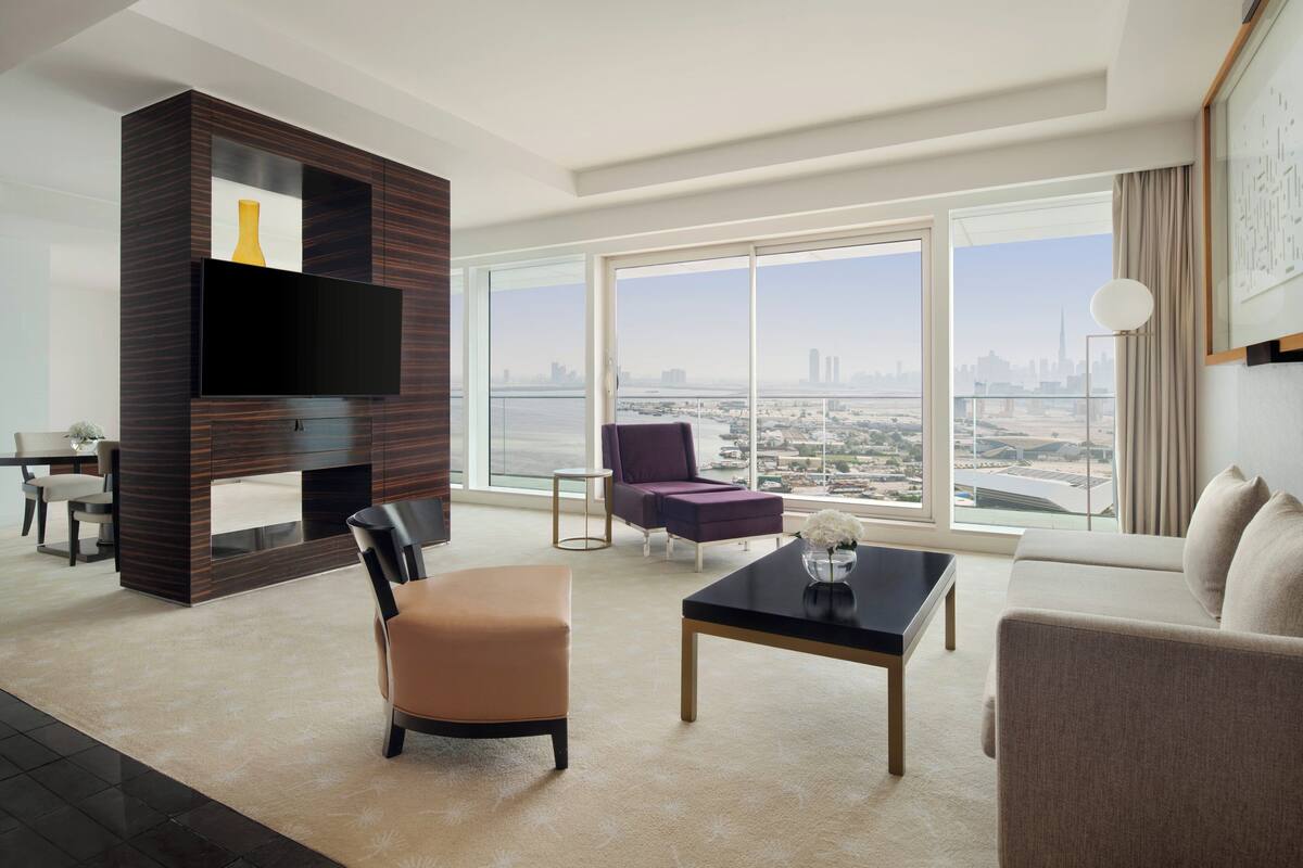 Una sala de estar moderna con un ventanal grande, un televisor de pantalla plana y vistas a la ciudad.
