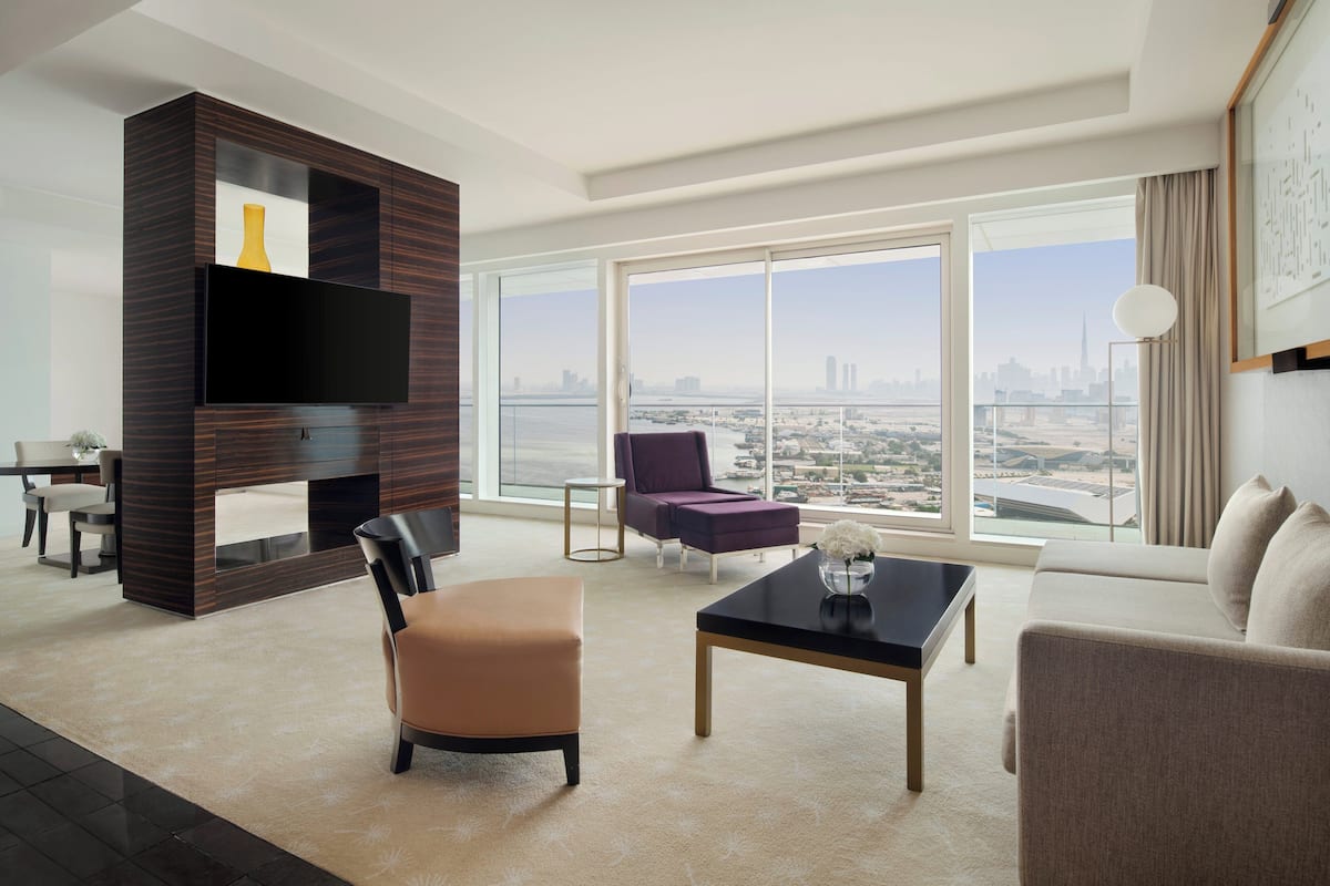 A modern living room with a large window, a flat-screen TV, and a city view.