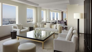 Una sala de estar moderna con una mesa de centro de vidrio, dos sofás y vistas a un paisaje urbano.