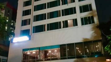 A multi-story hotel with a modern design, featuring a prominent entrance with glass doors and a well-lit facade.