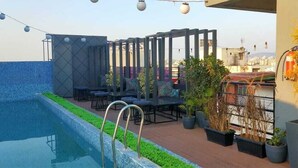 A rooftop pool area with a seating area and potted plants. - Royal Orchid Central Jaipur (Jaipur)