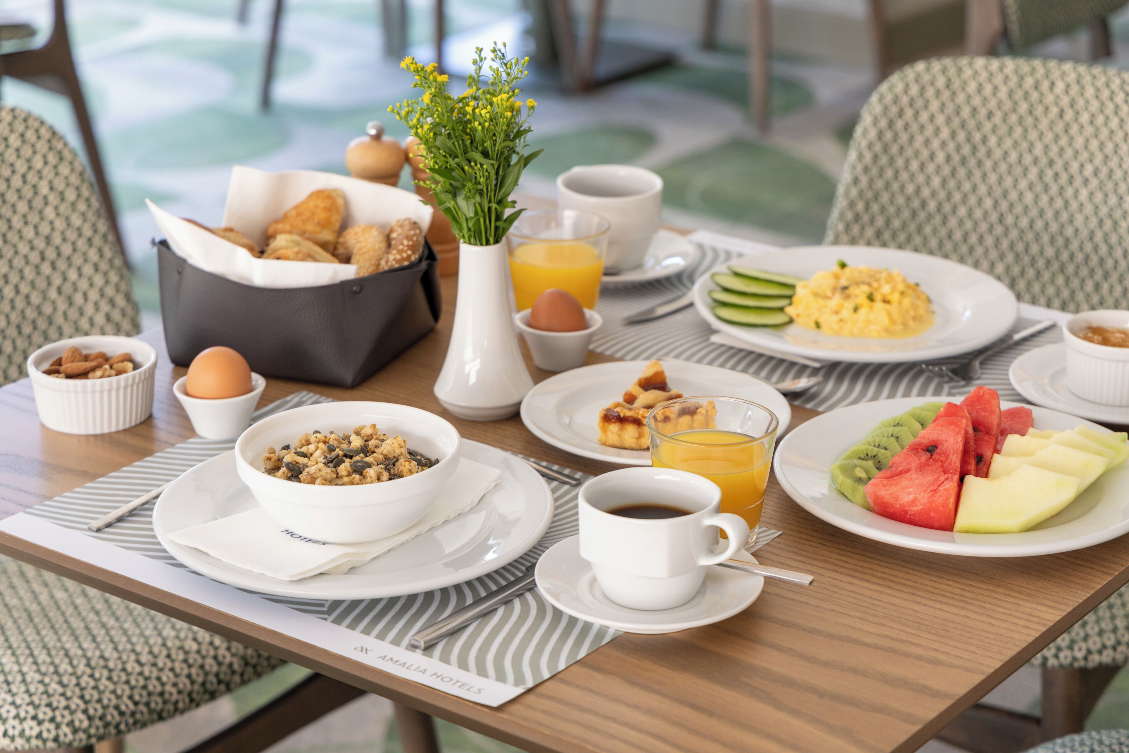 Una mesa de desayuno con diversas opciones de comida, una taza de café y un vaso de jugo de naranja.