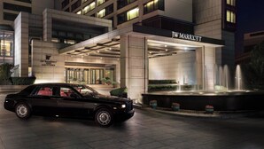 A JW Marriott hotel entrance with a black luxury car parked in front, a fountain, and a well-lit facade. - JW Marriott Hotel Beijing (Beijing)