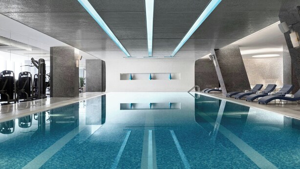 A modern indoor swimming pool with clear lanes, exercise equipment, and lounge chairs. - JW Marriott Hotel Beijing (Beijing)