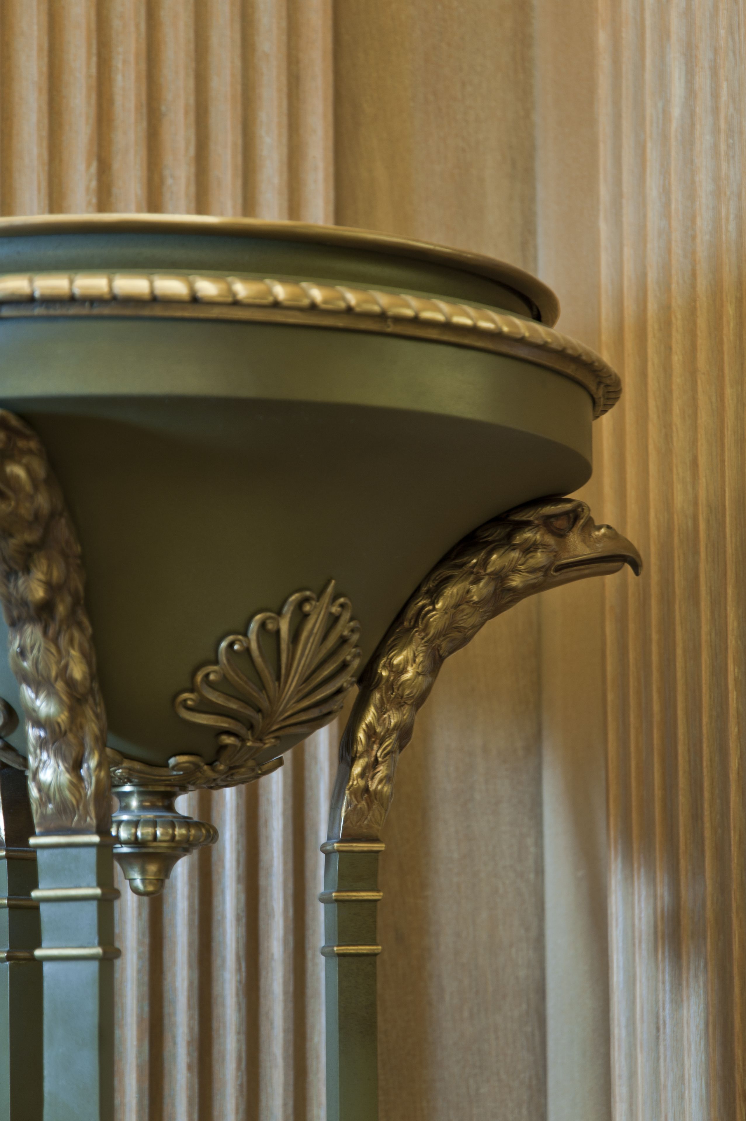 A close-up of a table with ornate metalwork and a decorative leaf pattern.