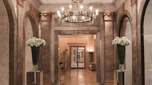 A grand hallway with marble columns, a checkered floor, and a chandelier. - NH Collection Buenos Aires Lancaster (Buenos Aires)