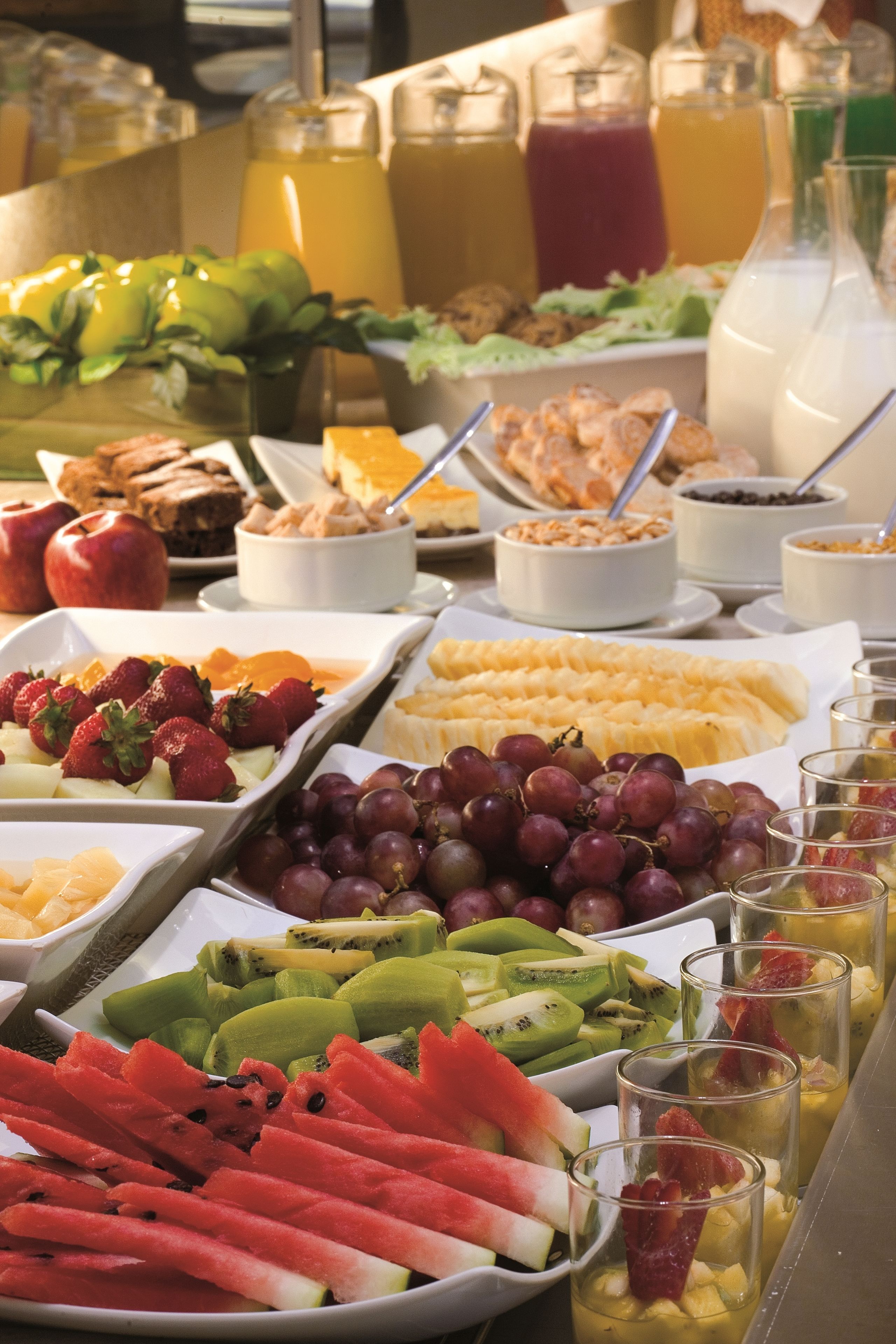 Um buffet com frutas, legumes e bebidas variadas.