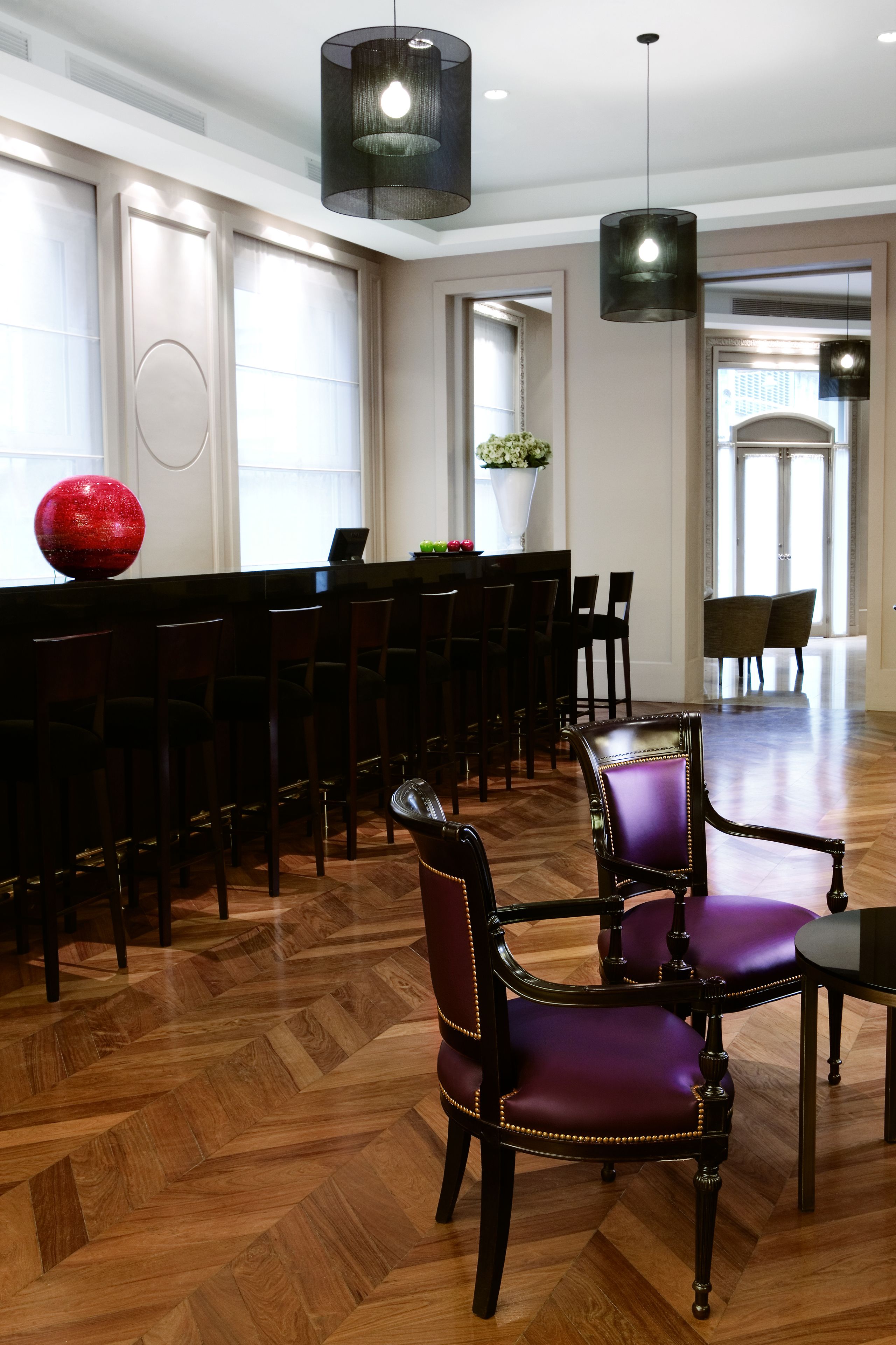 Un comedor amplio con suelo de madera, una mesa larga y varias sillas.