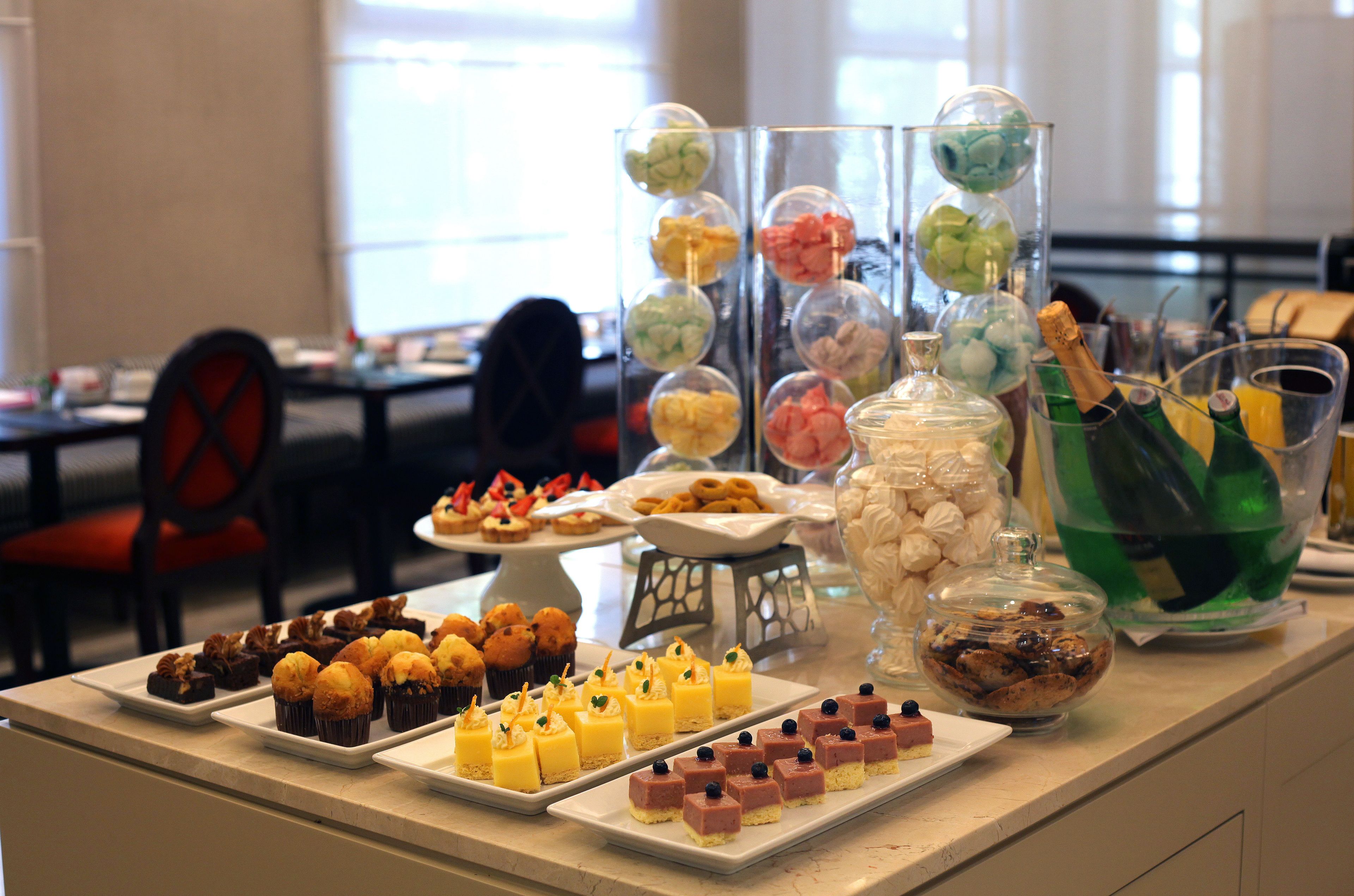 A buffet table with various desserts and beverages.