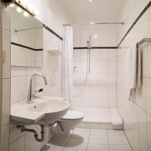 A modern bathroom with a sink, toilet, and shower. - Hotel Niederrad - Self Check In (Frankfurt)