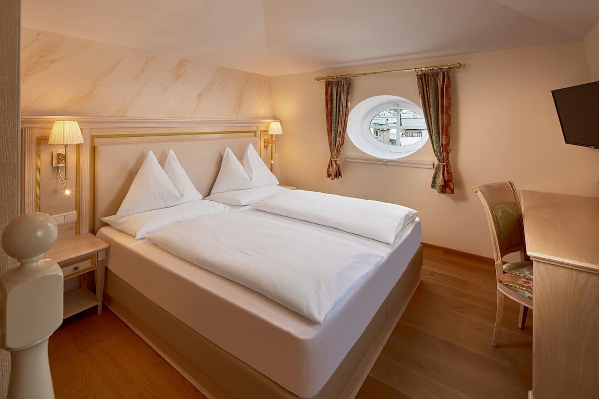 Une chambre d’hôtel avec un grand lit, des lampes de chevet, un bureau et une télévision.