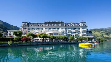Un hotel grande e histórico con varios balcones y vista al agua.