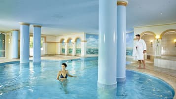 Una piscina techada, sillones reclinables de piscina