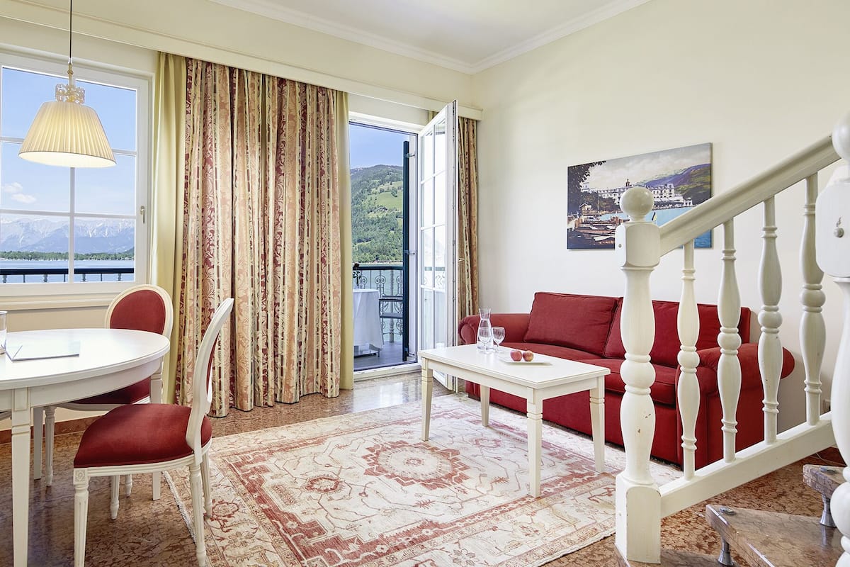 Une pièce comprenant une table à manger, des chaises, un canapé, une table basse et un escalier.