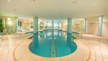 Una piscina techada, sillones reclinables de piscina