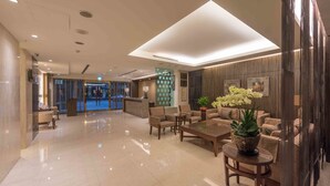 A modern hotel lobby with a reception desk, seating area, and a large window. - Royal Biz Taipei (Taipei)