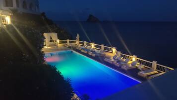 Una piscina al aire libre, tumbonas