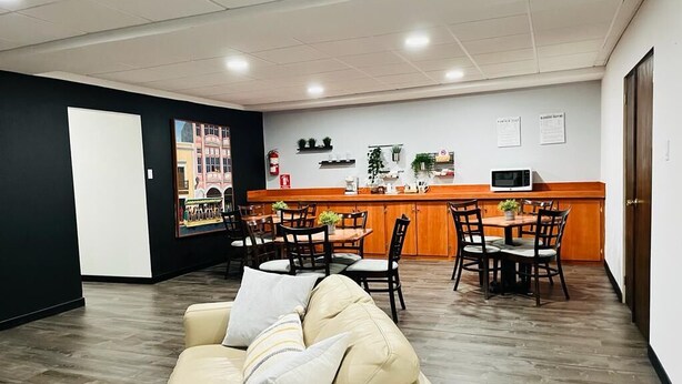 A modern interior with a sofa, dining area, and kitchen counter. - S.J. Suites Hotel (San Juan)