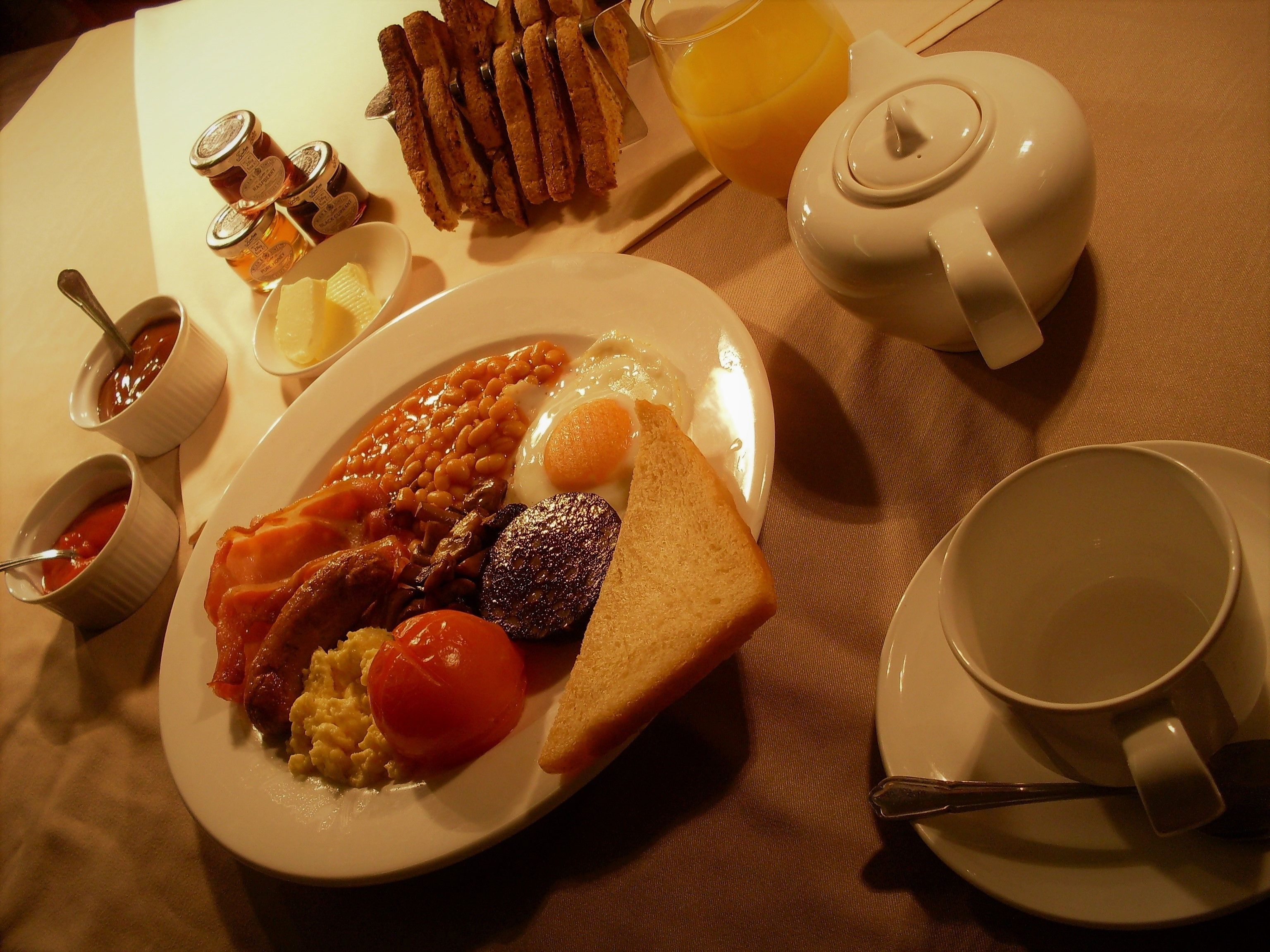 A breakfast plate with eggs, bacon, tomatoes, toast, and beans.