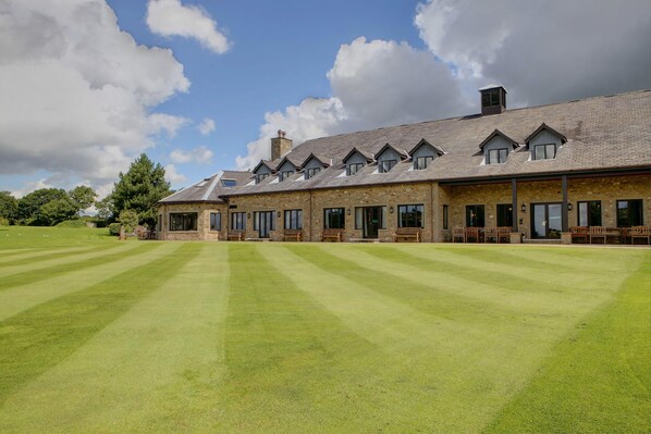 A large building with multiple windows and a well-maintained lawn.