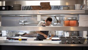 A chef preparing food in a professional kitchen with stainless steel surfaces, organized utensils, and a clean, modern design. - Best Western Bristol North The Gables Hotel (Wotton-under-Edge)
