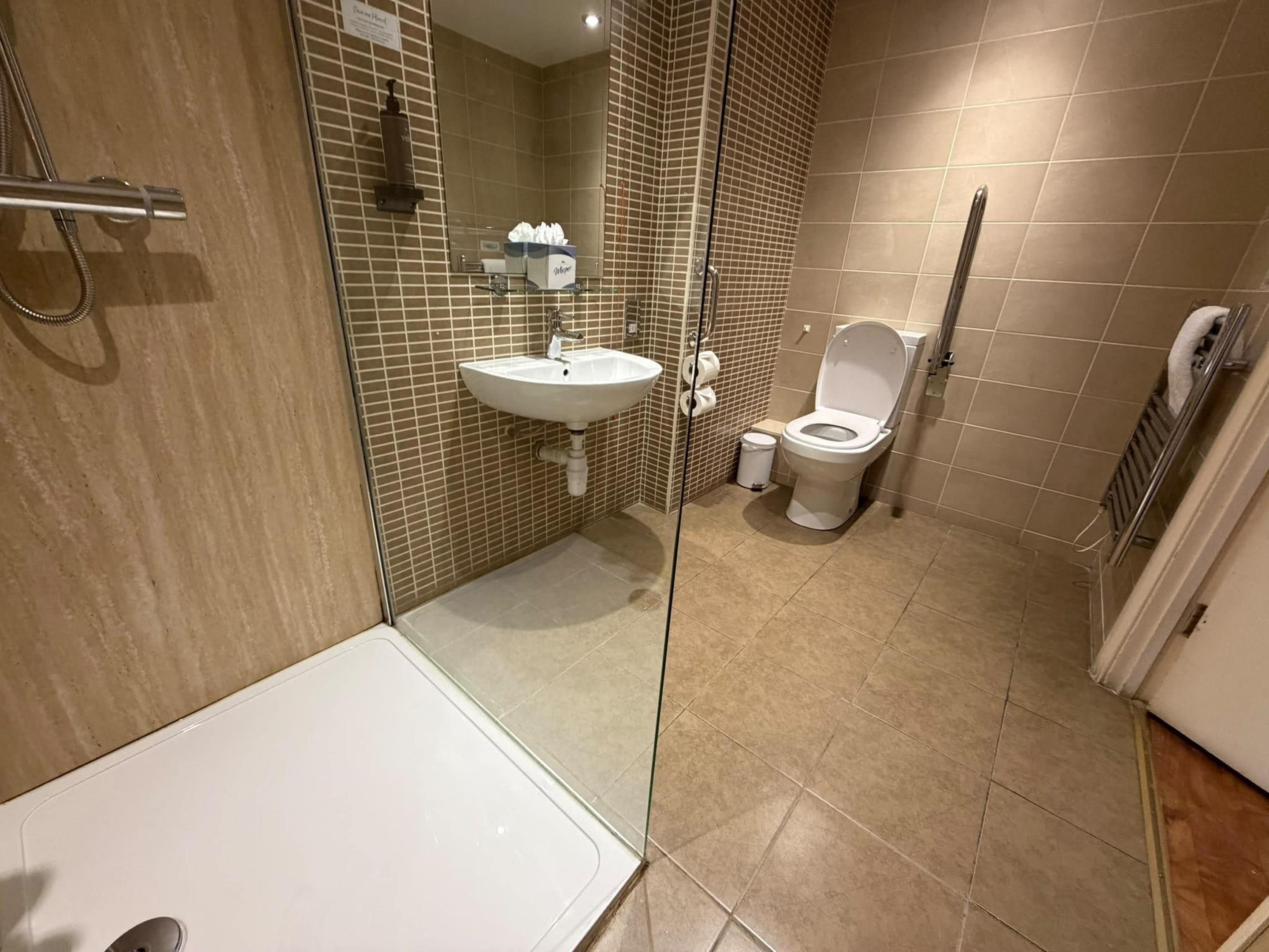 Un baño con bañera, lavamanos, inodoro y ducha.