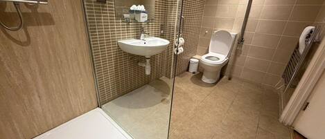 Un baño con bañera, lavamanos, inodoro y ducha.