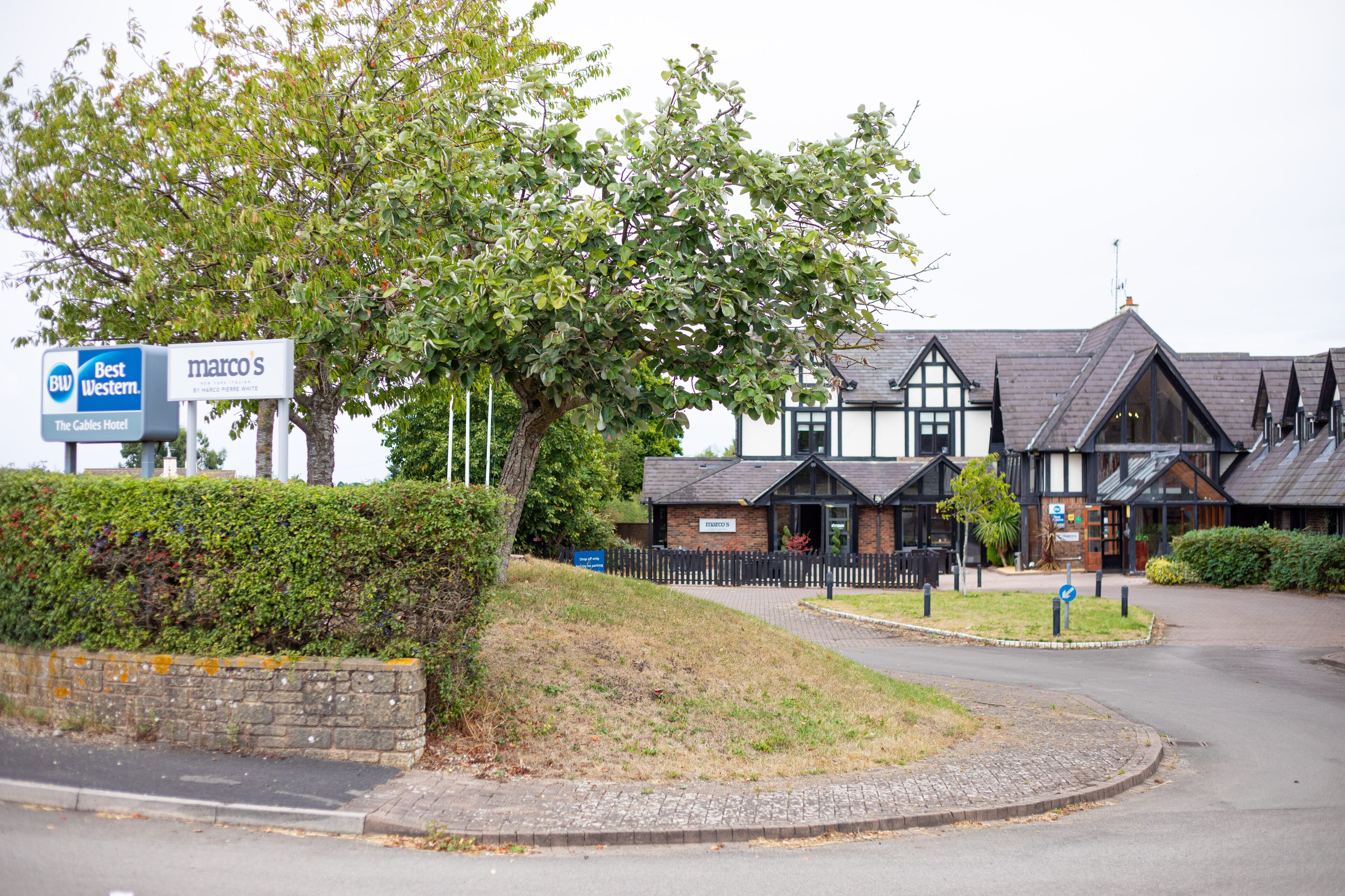 A traditional building with a sign for 'Marco's' and 'Best Western' hotel.