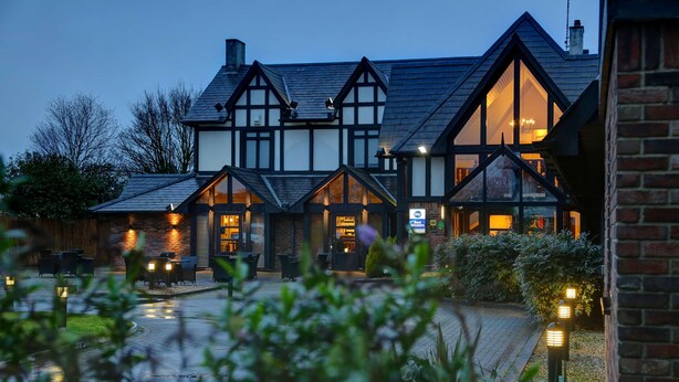 A traditional Tudor-style building with multiple gabled roofs and large windows.