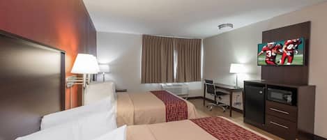 Quarto de hotel com duas camas, uma mesa, televisão e minibar.