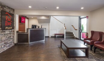 Un área de recepción con un mostrador, un banco, una escalera y un extintor.
