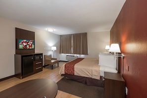 Une chambre d’hôtel équipée d’un lit, de lampes de chevet, d’une télévision, d’un bureau et d’une chaise.