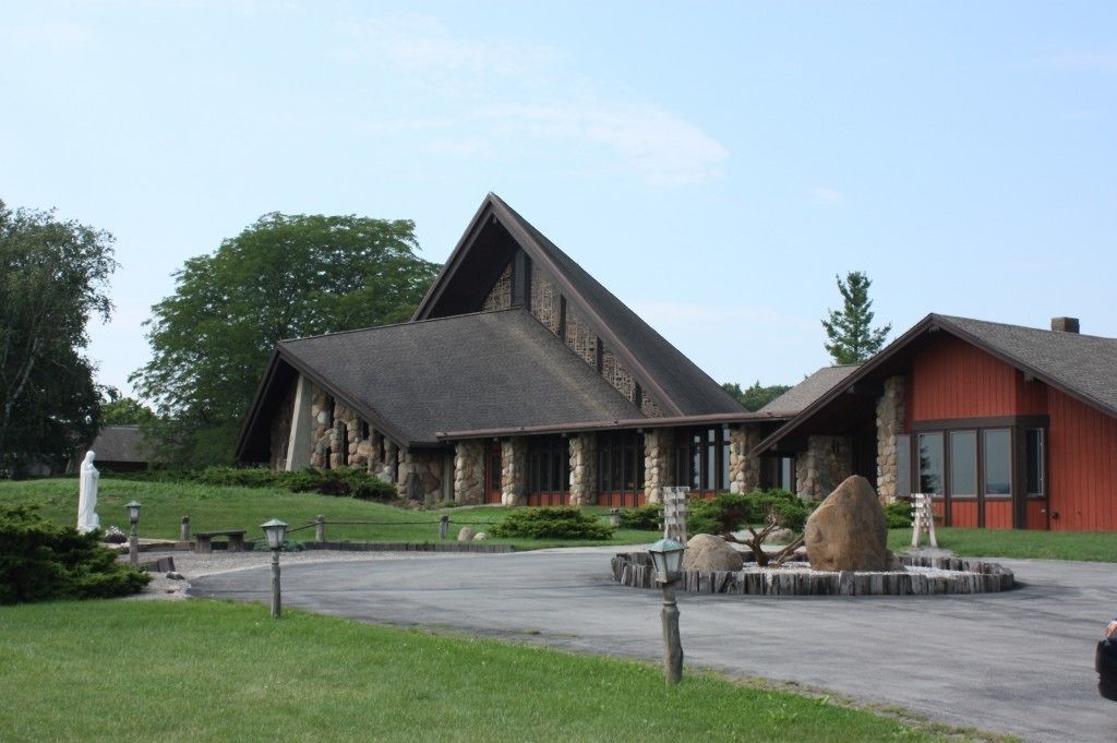 Ein Steinhaus mit einem markanten, dreieckigen Dach und einer roten Außenwand.