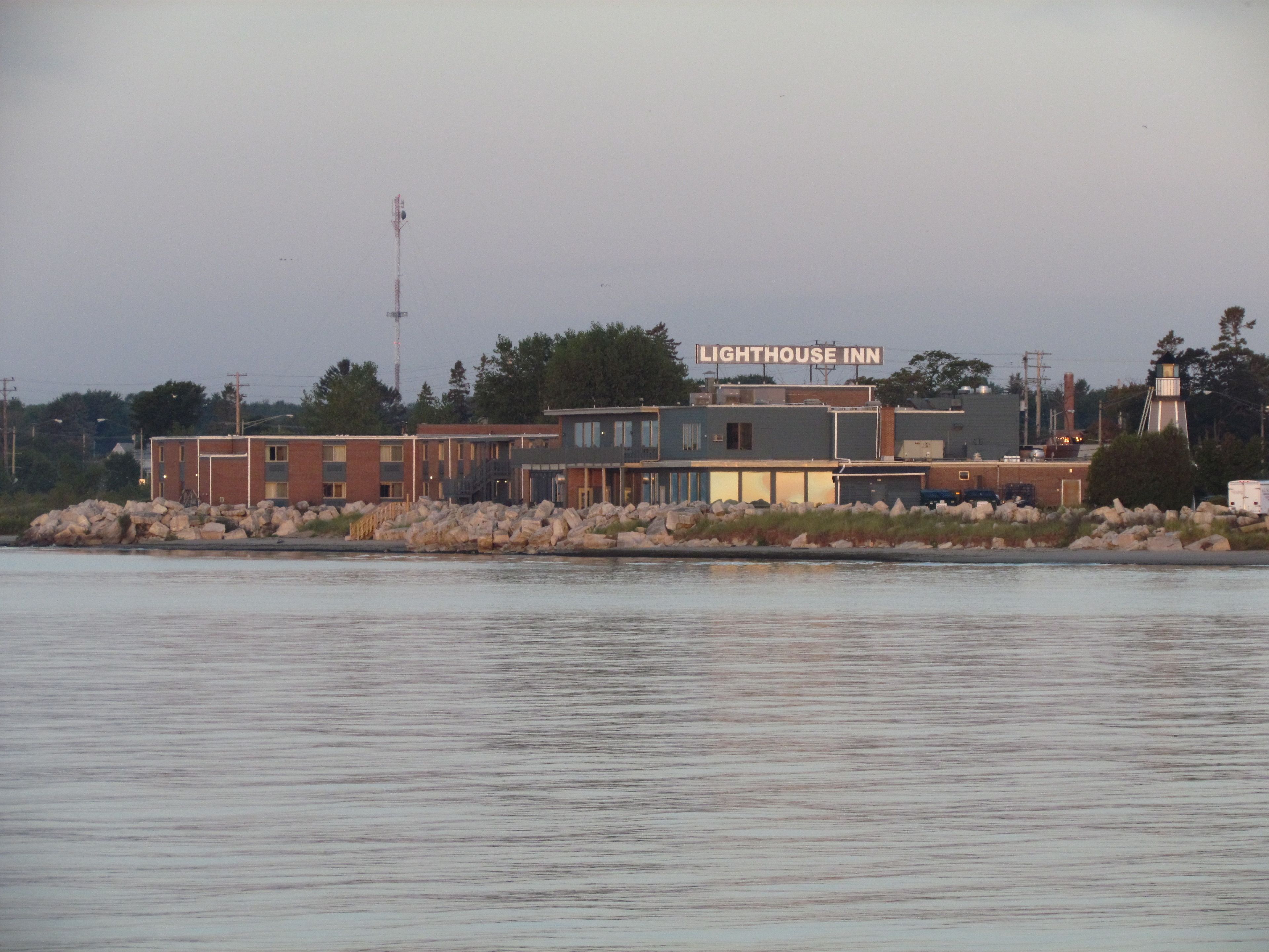 A waterfront building with a sign reading "Lighthouse Inn."