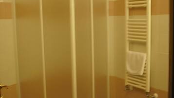 Ein Badezimmer mit Duschkabine, Waschbecken und Handtuchhalter.