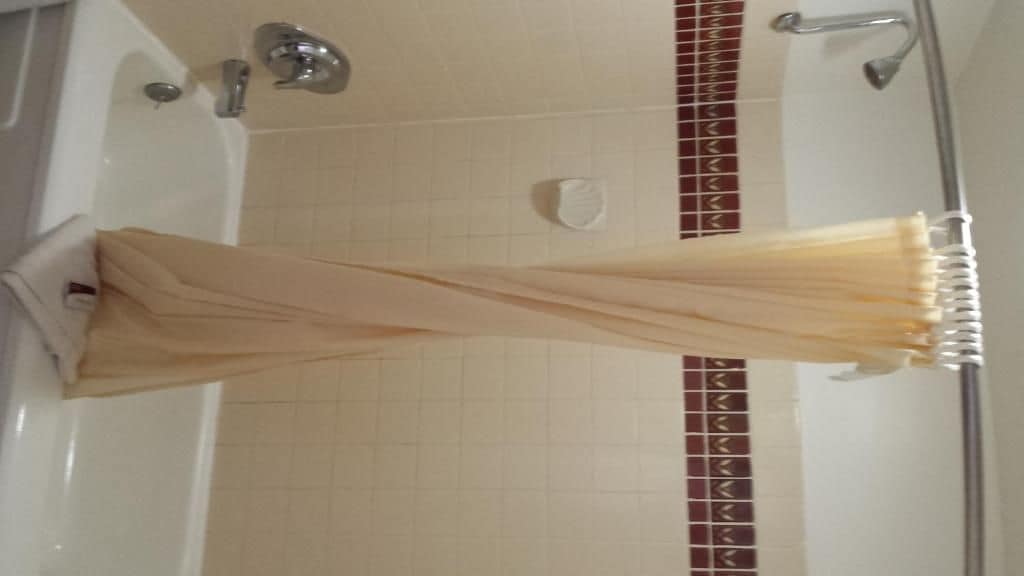 Une salle de bain avec une baignoire, une douche et un porte-serviettes.