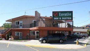A two-story building with a sign for 'Executive Inn & Suites'.