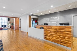 Un mostrador de recepción con un letrero que dice 'Welcome to Volunteer State', un mostrador de madera y un diseño de interiores moderno.