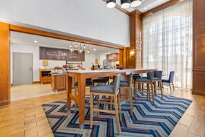 Una cocina moderna con una isla central, asientos tipo bar y una barra desayunadora.