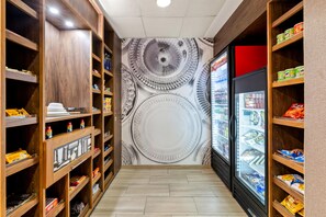 A narrow corridor with wooden shelving on both sides, stocked with various food items and beverages. - Hampton Inn & Suites Murfreesboro (Murfreesboro)