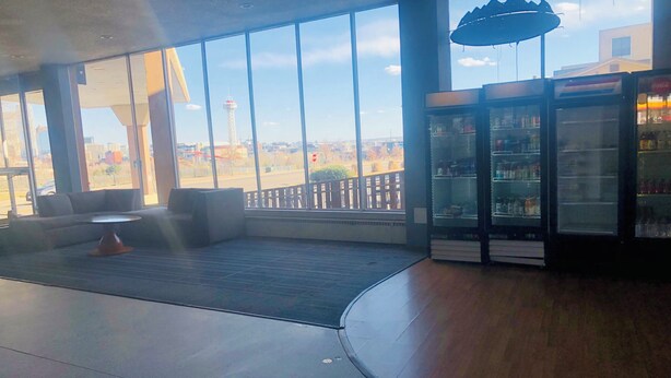 Un interior moderno con ventanas amplias, un área de estar y un refrigerador para bebidas.