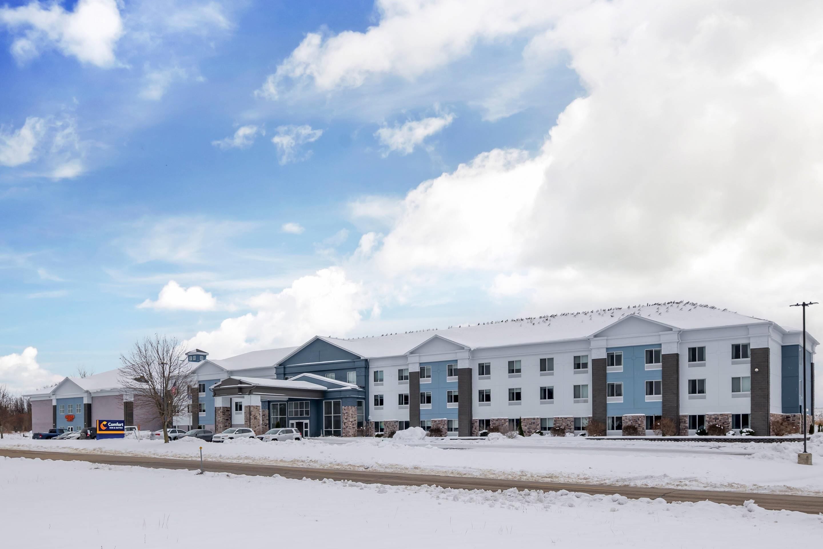 A multi-story hotel with a snow-covered parking lot and a clear sky.