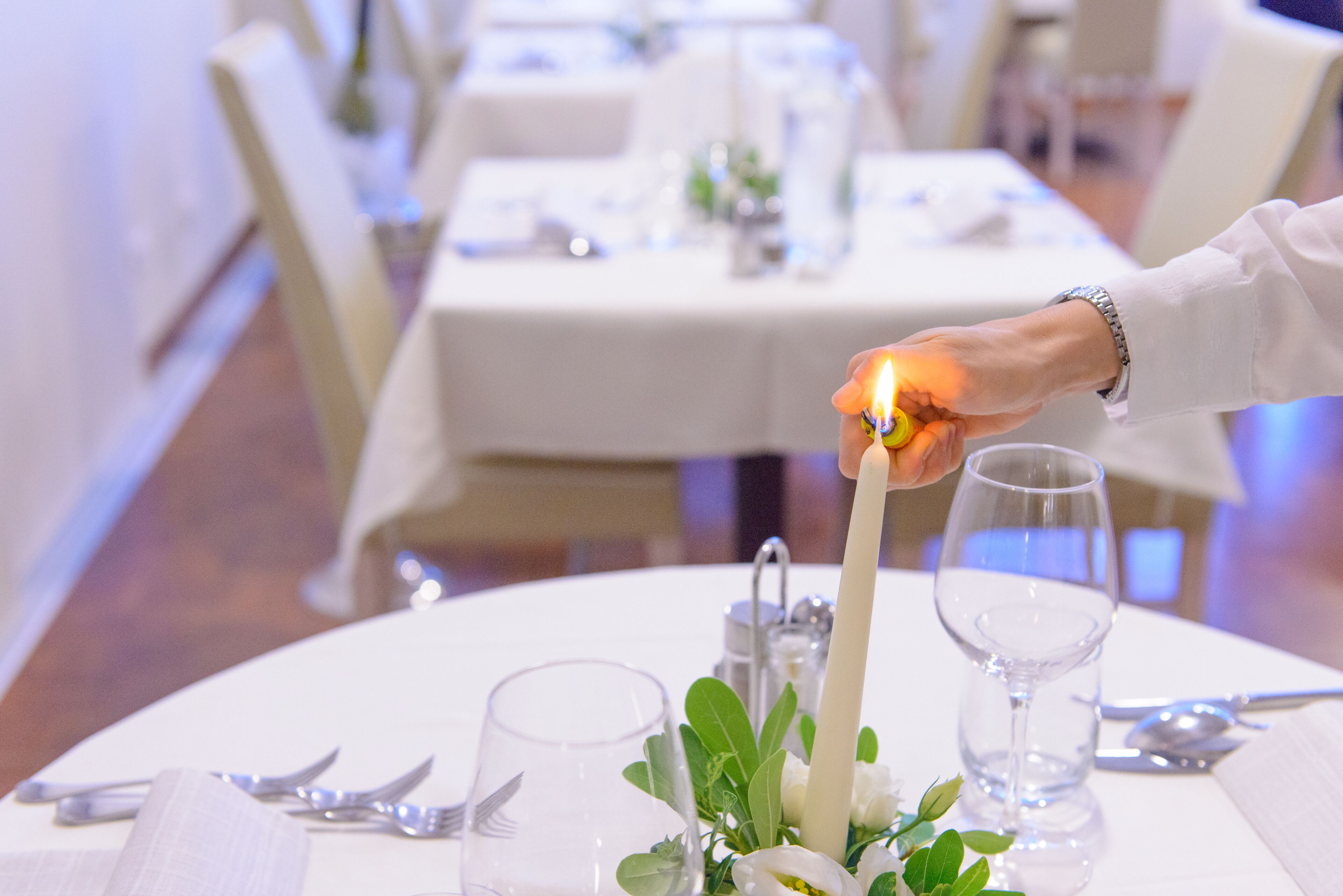 A table set for dining with a candle, clear glassware, and a napkin.