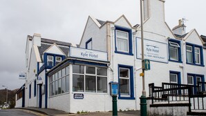 Ein weißes Gebäude mit blauen Akzenten und einem Schild mit der Aufschrift "Kyle Hotel".