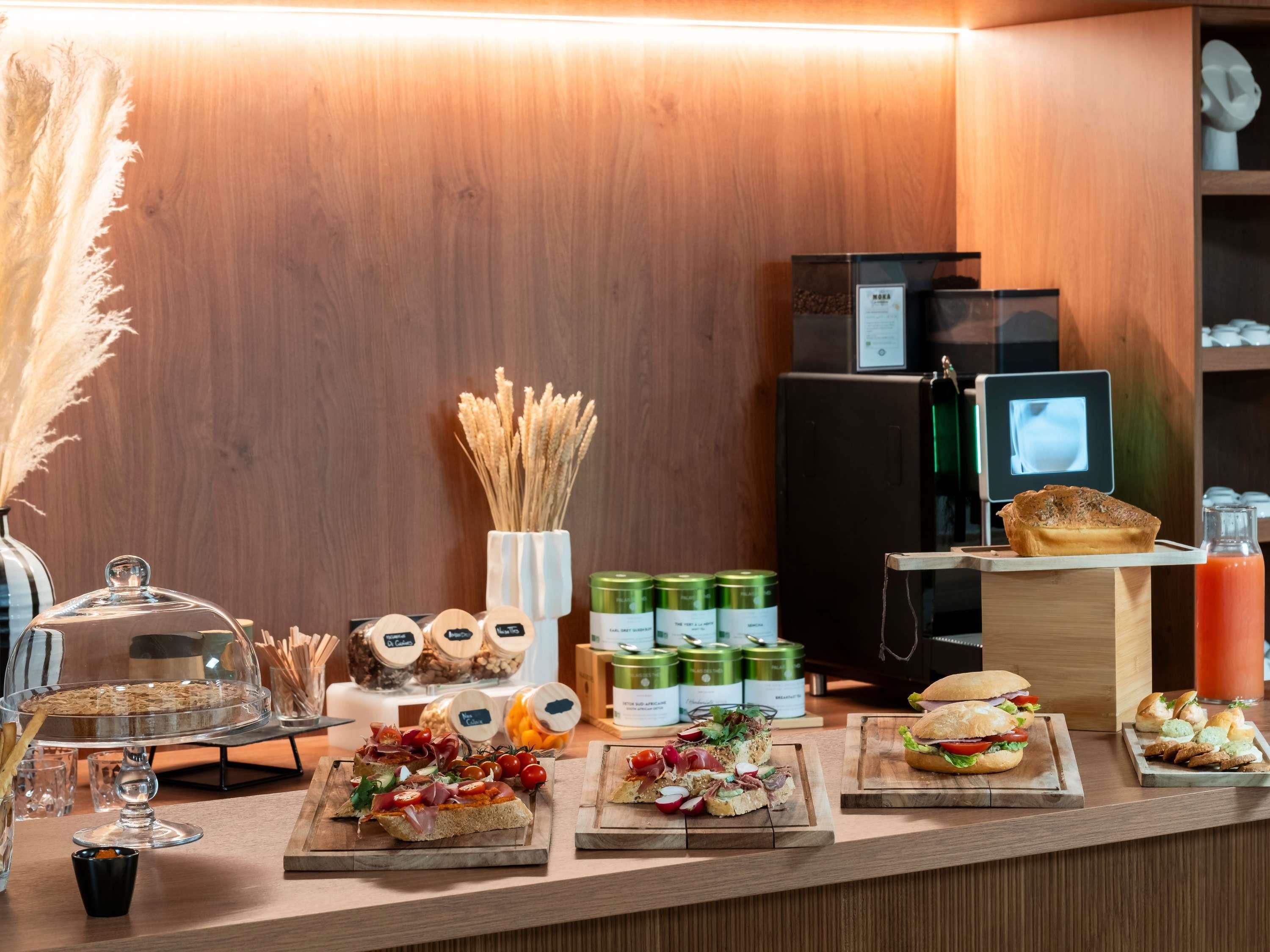 A buffet counter with various food items and condiments.