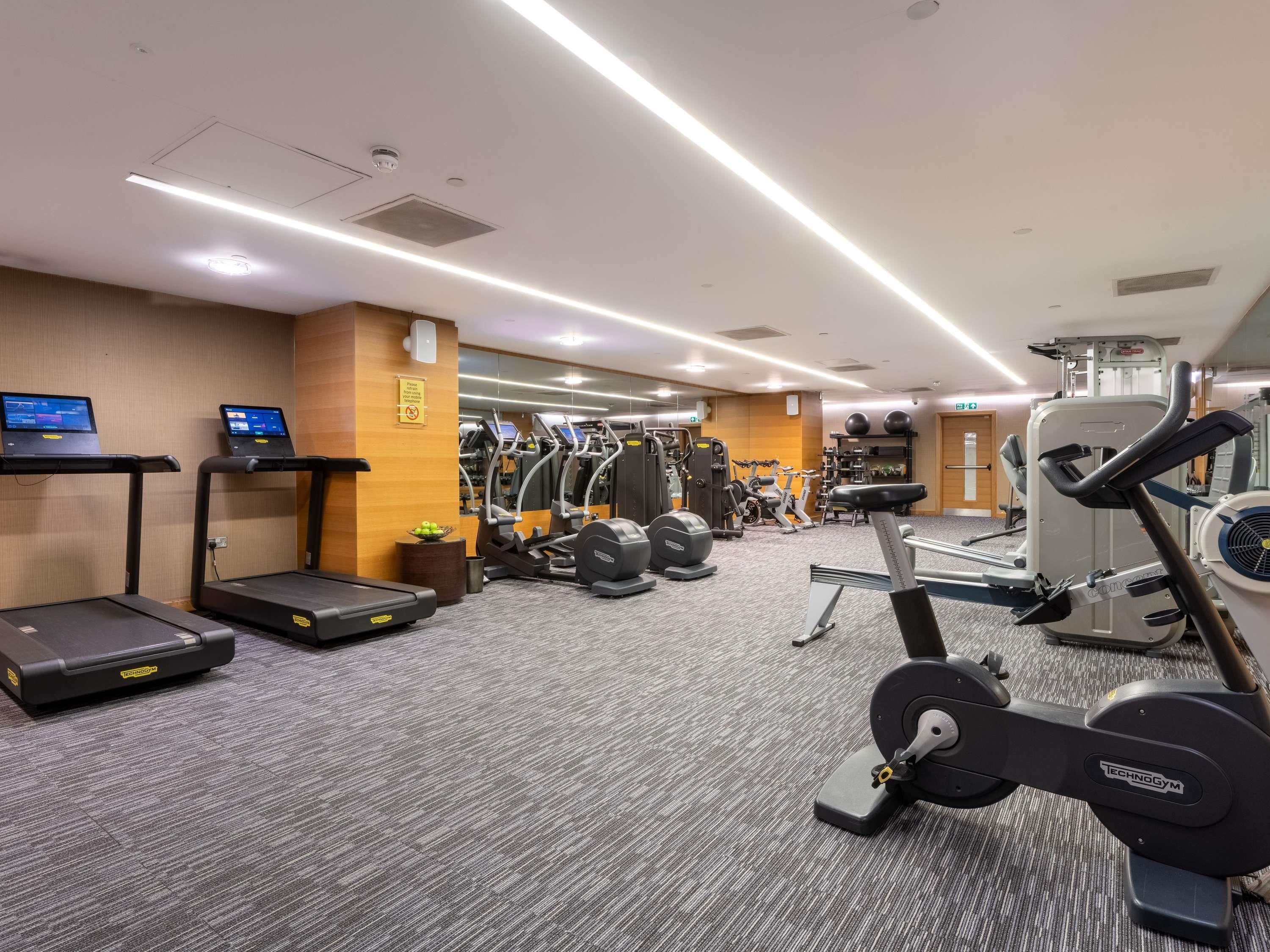 A gym with treadmills, elliptical machines, and weight equipment.