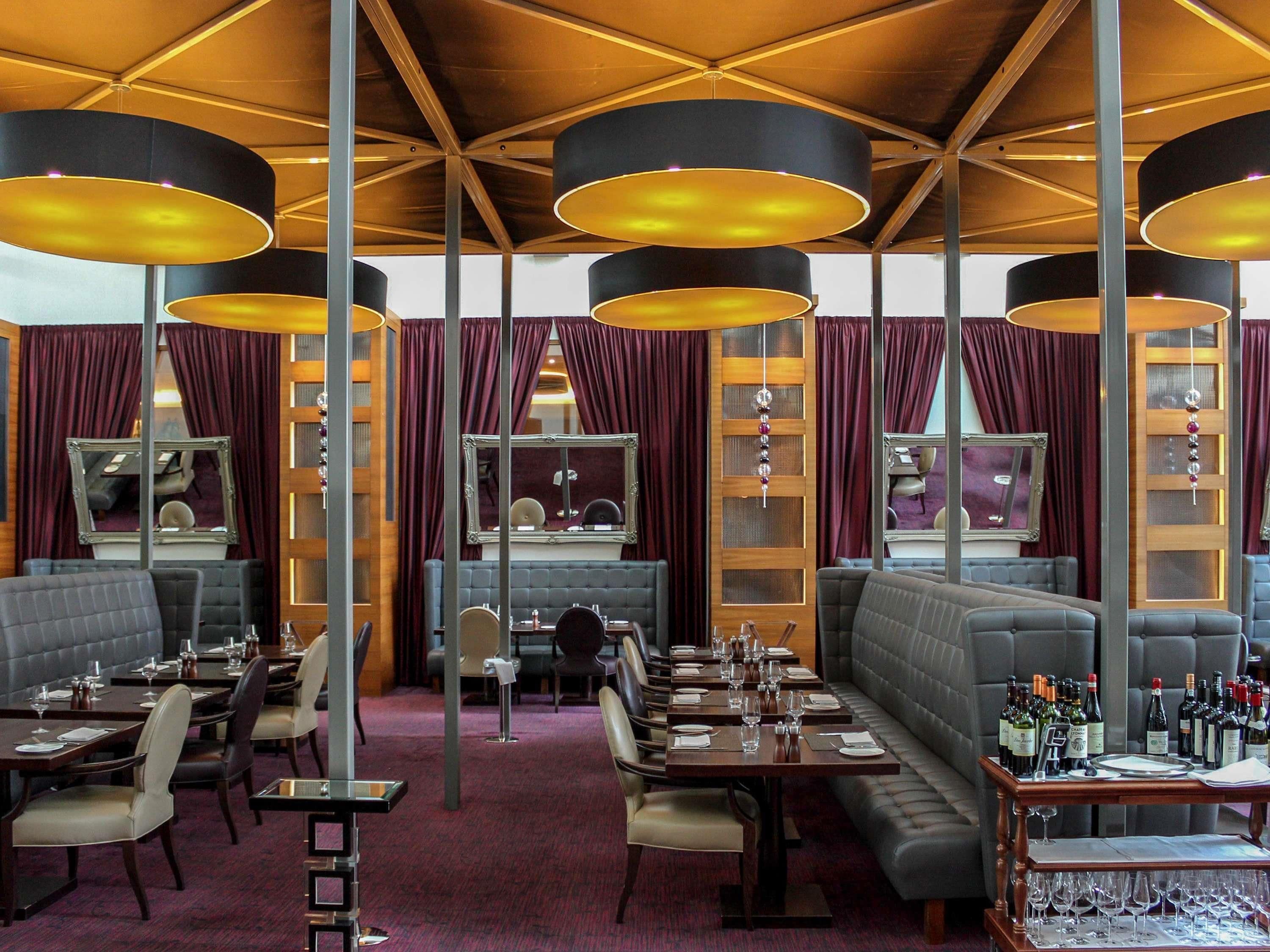 A restaurant with multiple dining tables, booths, and a bar area.