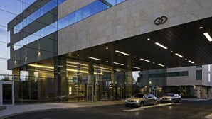 Een modern gebouw met een glazen gevel en een overdekte ingang.